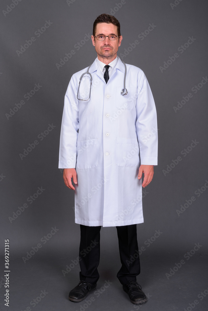 Portrait of handsome bearded man doctor against gray background Portrait of handsome bearded man doctor against gray background
