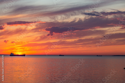 Silhouette of ships on background out at sea at beautiful sunset © volis61
