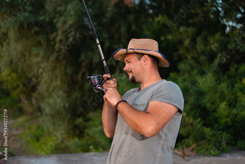 Young attractive man smiling while fishing