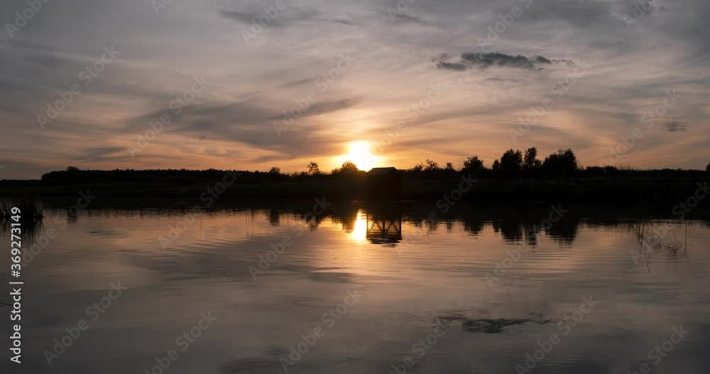 Colorful cloudscape time lapse with the sky reflecting off the surface of the lake. Sunset over the pond. 4K Time lapse of beautiful lake in evening. Colorful cloudscape time lapse with the sky reflecting off the surface of the lake. Sunset over the pond. 4K Time lapse of beautiful lake in evening.