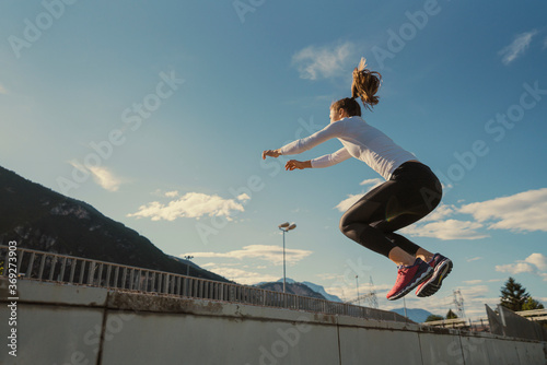 Athletic woman training in the urban area near the mountains.