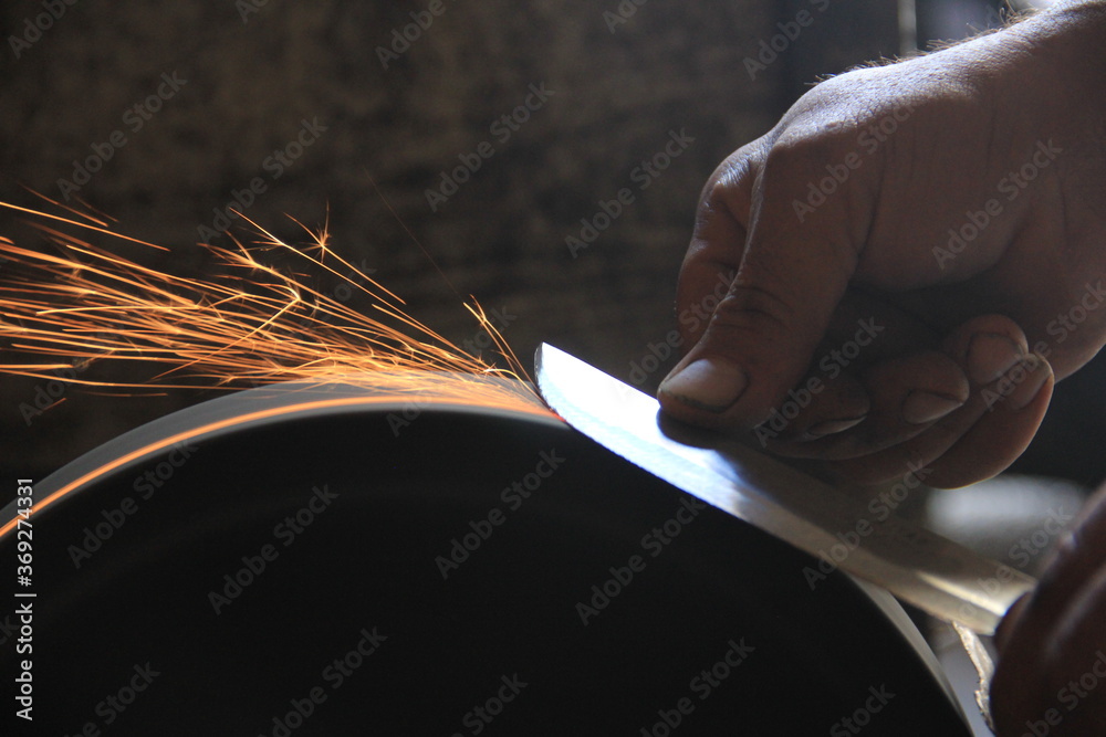 Sparks grinding wheel while knife sharpening Stock Photo