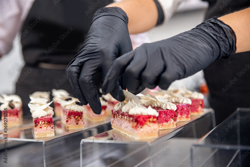Chef hand in patisserie restaurant prepares cakes and decorates with chocolate icing Chef hand in patisserie restaurant prepares cakes and decorates with chocolate icing