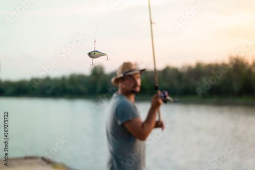 Close up of fishing tackle with fisherman in blurred background