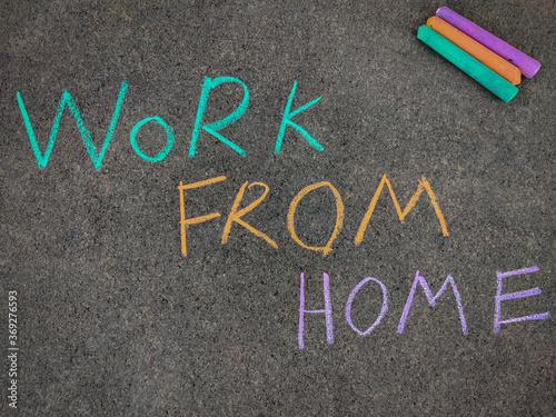 The inscription text on the grey board "WORK FROM HOME". Using color chalk pieces. Due to corona virus pandemic