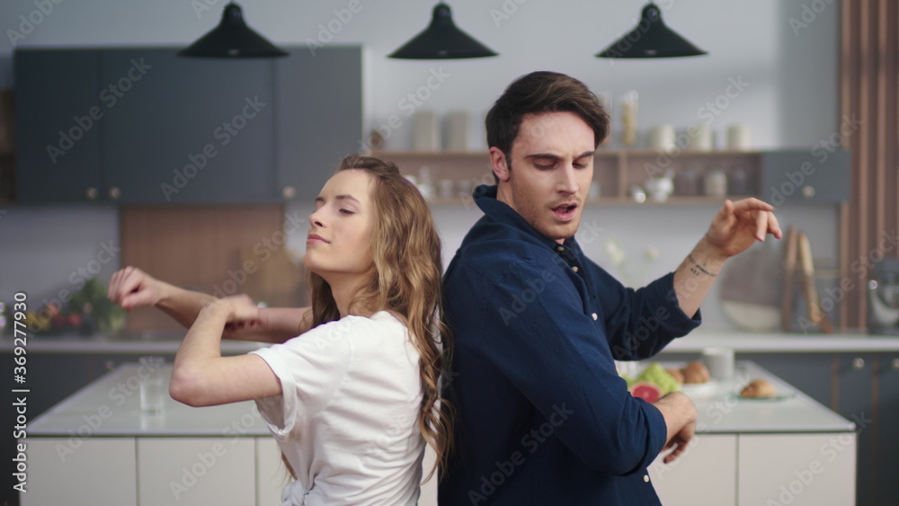 Happy man and woman dancing back to back at home kitchen in slow motion. Happy man and woman dancing back to back at home kitchen in slow motion.