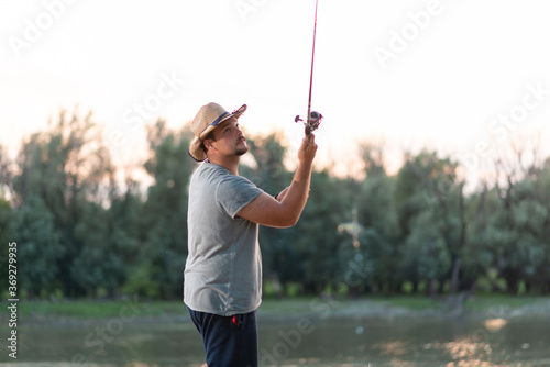 Young fisherman throwing fishing lure 