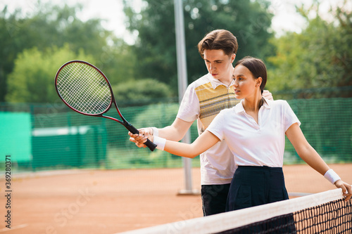 Coach teaches a girl to play tennis © Andrii 
