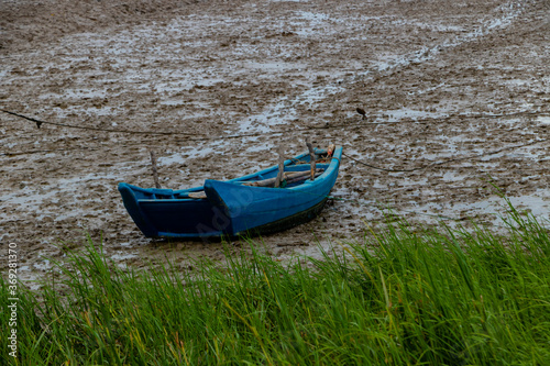 A small wooden boat that ran aground on the beach.