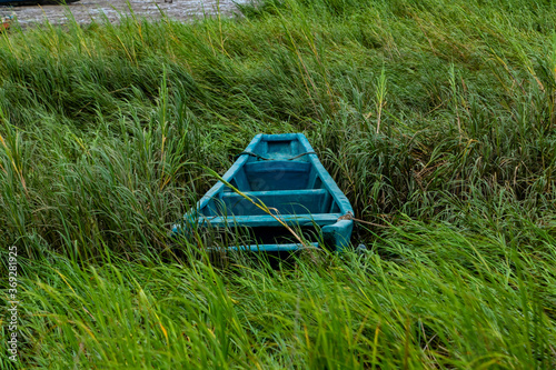 A small wooden boat that ran aground on the beach.