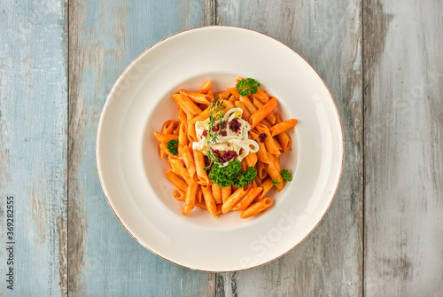 Penne pasta in tomato sauce with  cheese  tomatoes decorated with parsley