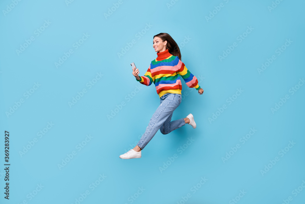 Full length body size profile side view of her she nice attractive pretty cheerful cheery girl jumping running using 5g app fast speed wi-fi roaming isolated blue pastel color background Full length body size profile side view of her she nice attractive pretty cheerful cheery girl jumping running using 5g app fast speed wi-fi roaming isolated blue pastel color background