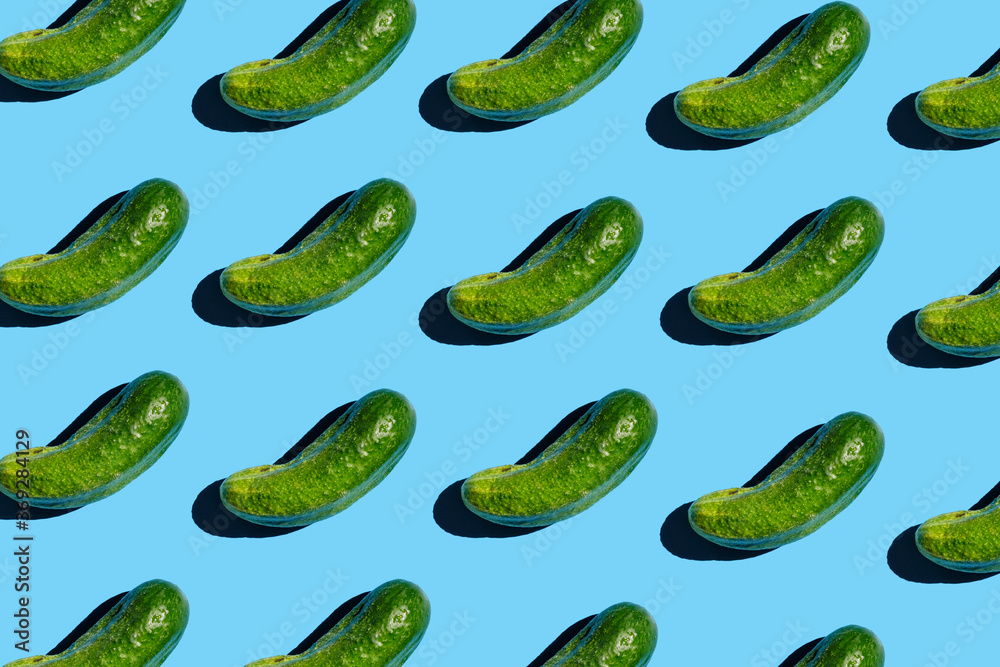 Flat lay of trendy seamless pattern cucumbers. Pattern of green cucumbers on a blue background. Vegans concept. Suitable for posters, packaging, postcards Flat lay of trendy seamless pattern cucumbers. Pattern of green cucumbers on a blue background. Vegans concept. Suitable for posters, packaging, postcards
