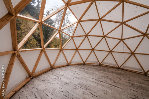 Obraz na płótnie Interior of large geodesic wooden dome tent with window and view to forest
