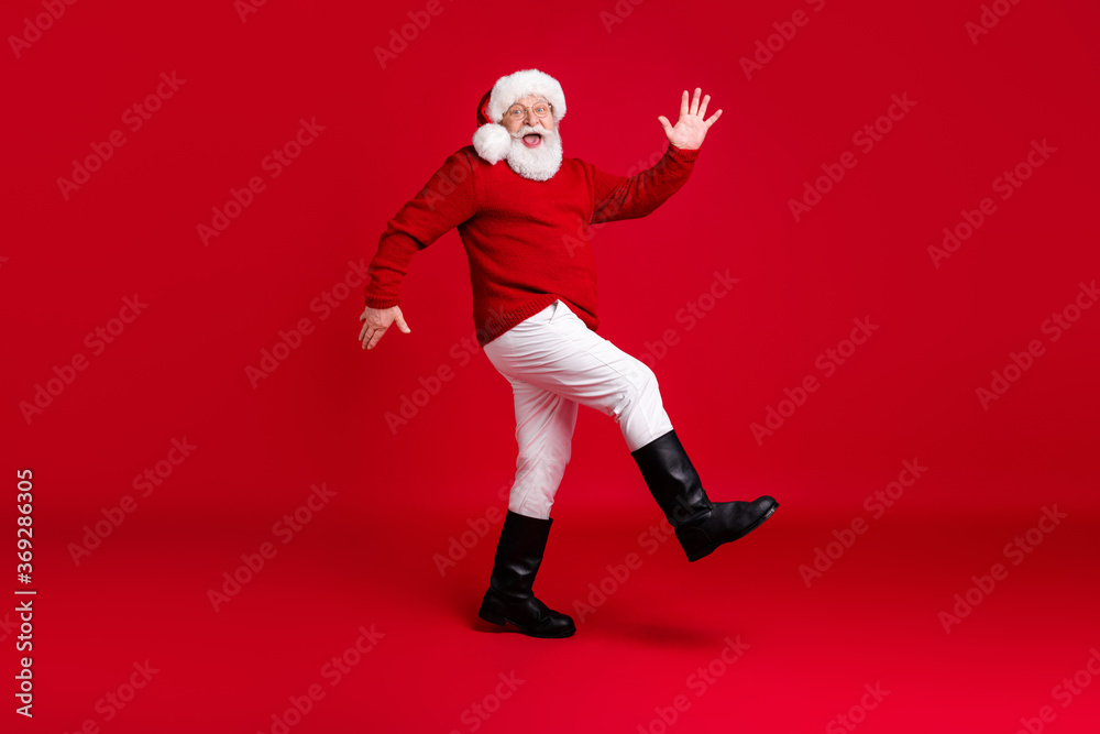 Full body profile side photo funny old man retired pensioner santa claus headwear go walk copyspace jolly holly tradition event wear x-mas outfit boots isolated bright shine color background