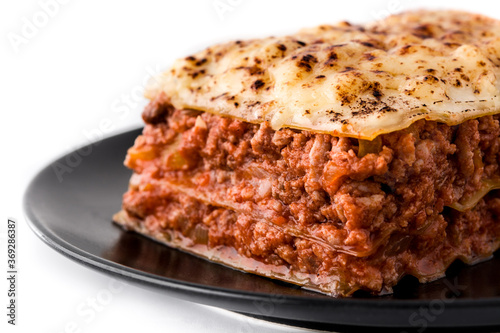 Piece of meat lasagna on black plate isolated on white background