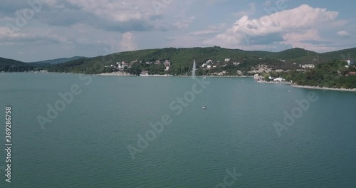 aerial video shooting from a drone flying over a lake against the background of mountains at a low altitude