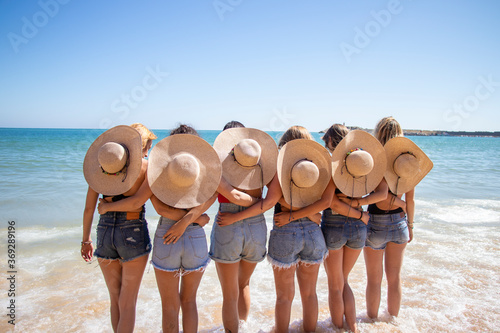 Chicas de espalda felices amigas verano vacaciones naturaleza sur españa amarillo gorros cielo azul photo