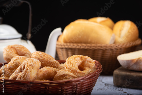 Breakfast table with cookies, breads and accessories on lace tablecloth and rustic wood, selective focus