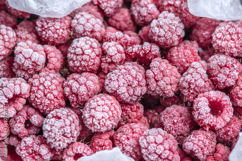 Large beautiful frozen raspberries close up. Concept of frozen food, long term storage products