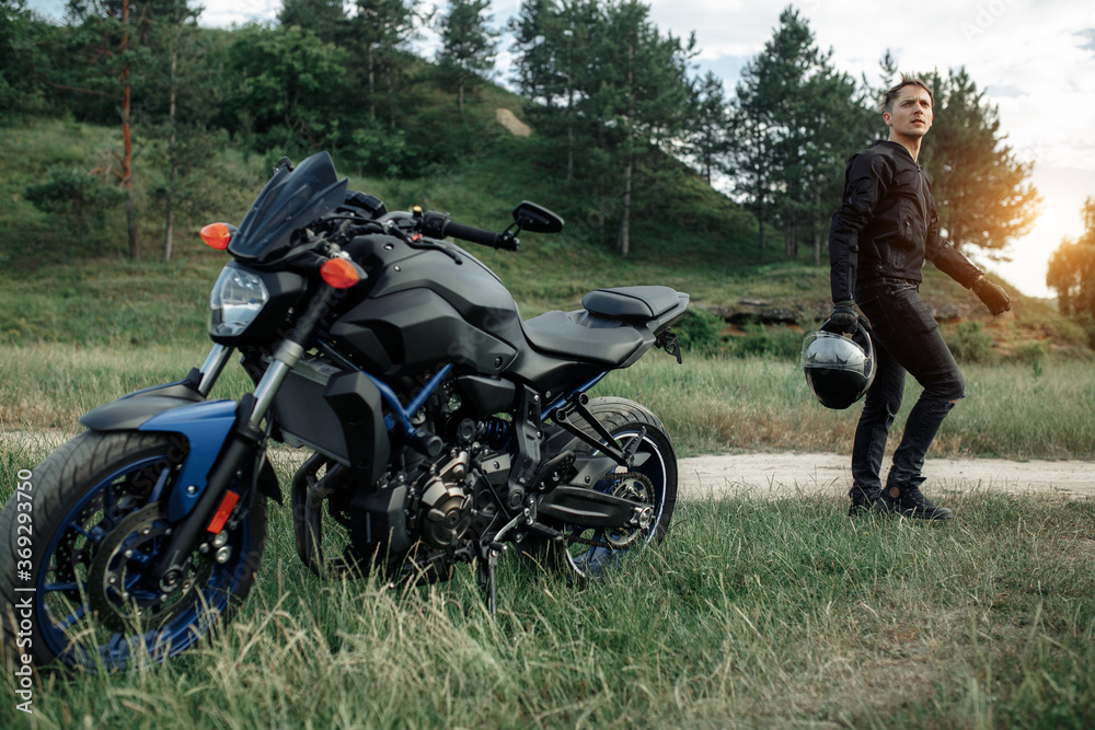 Image of biker and motorcycle on the country road. Image of biker and motorcycle on the country road.