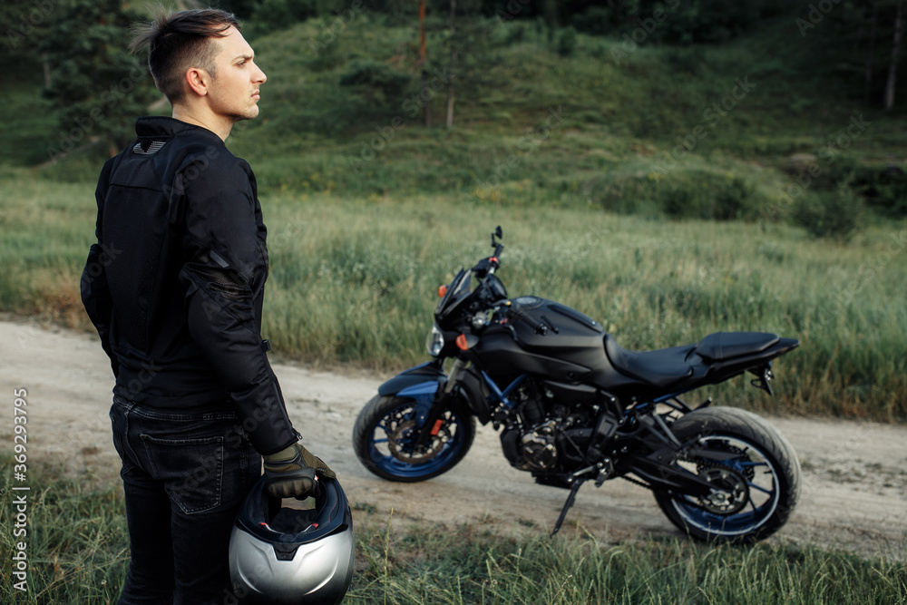 Obraz premium Image of biker and motorcycle on the country road.