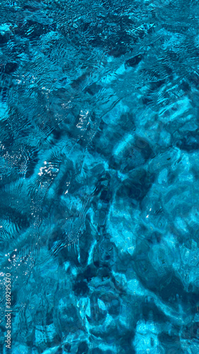 Swimming pool water texture in abstract style on blue background. Vacation  holiday. Ripple water. Swimming pool water sun reflection background. Summer vacation.