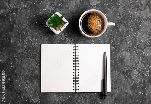 Notepad for notes with pen, cactus and coffee on gray table