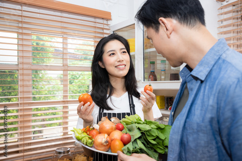 A lovely couple is making breakfast in the kitchen with their menu consists of many vegetables. Activities that build relationships and warmth in the family. Being a perfect and good family.