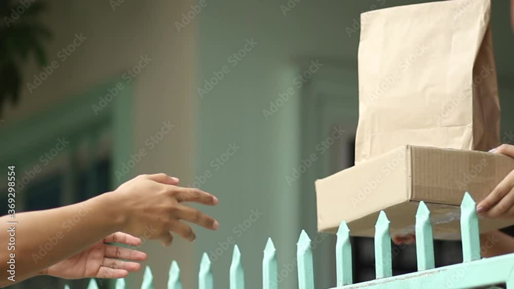 Delivery man sending papaer bag and packgage of product to his customer at font house.