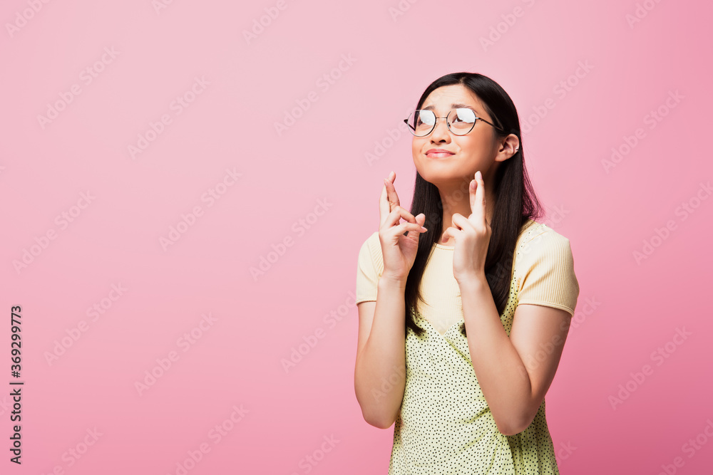 young asian woman in glasses standing with crossed fingers isolated on pink young asian woman in glasses standing with crossed fingers isolated on pink
