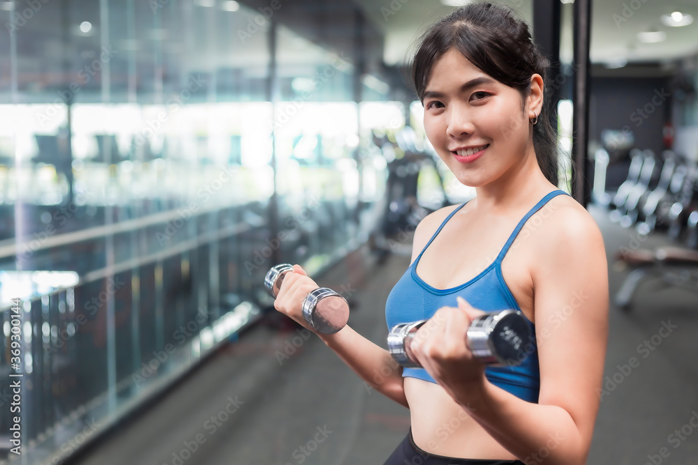 Asian woman Bodybuilder with dumbbell weights power athletic exercises.Metaphor Fitness and workout concept exercise Health lifestyle muscle body with take care of your health
