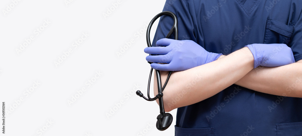 A doctor in a blue uniform with a stethoscope on a white background. Banner, copy space.