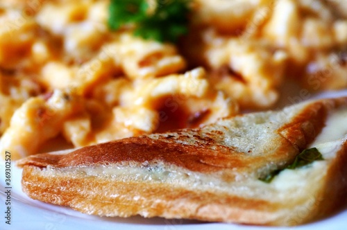 scrambled eggs with pieces of meat, parsley and toast