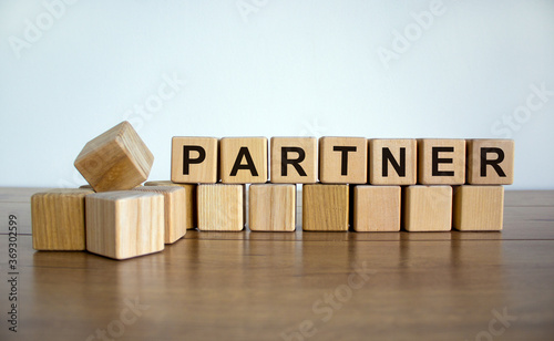 Concept word 'partner' on wooden cubes on a beautiful wooden table. White background. Business concept.