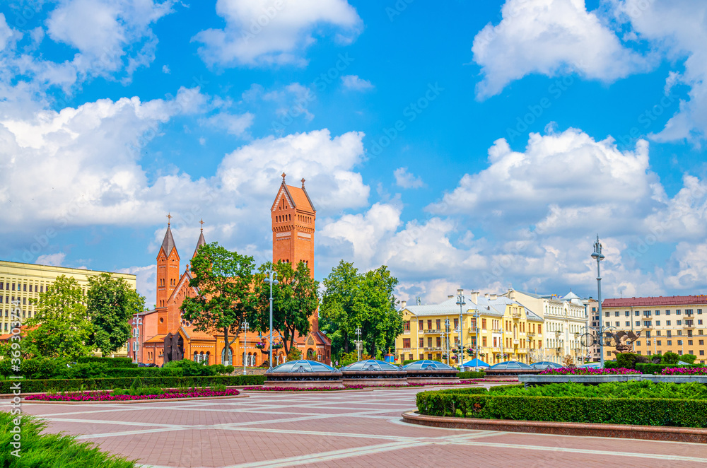Saints Simon and Helena Roman Catholic church or Red Church on Independence Square in Minsk city historical centre, blue sky white clouds in sunny summer day, Republic of Belarus
