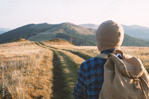 Man with oldstyle backpack on mountains road. Travel concept. Landscape photography