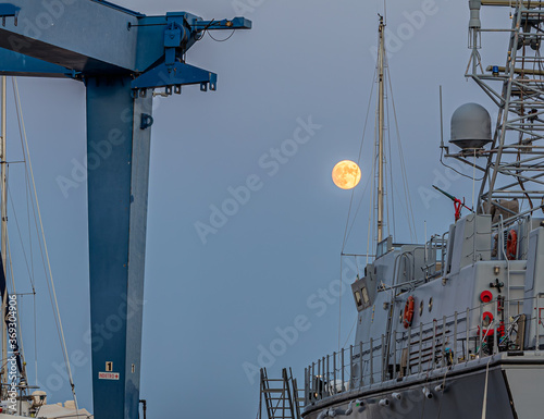 Luna piena al tramonto in un cantiere navale di Riposto photo