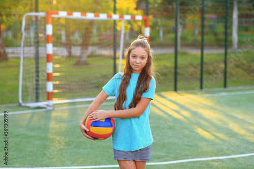 Girl with a ball in his hands on the football field. © Nadya Kolobova