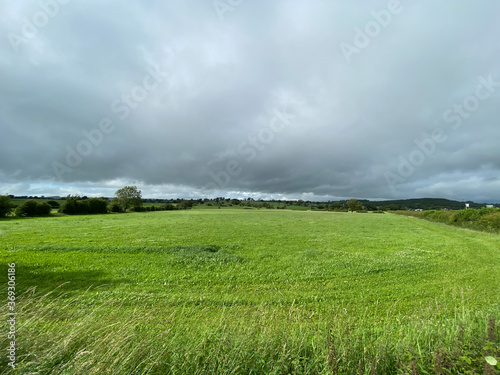 Large open green meadow, with heavy rain cloud above in, Pool, Harrogate, UK © derek oldfield
