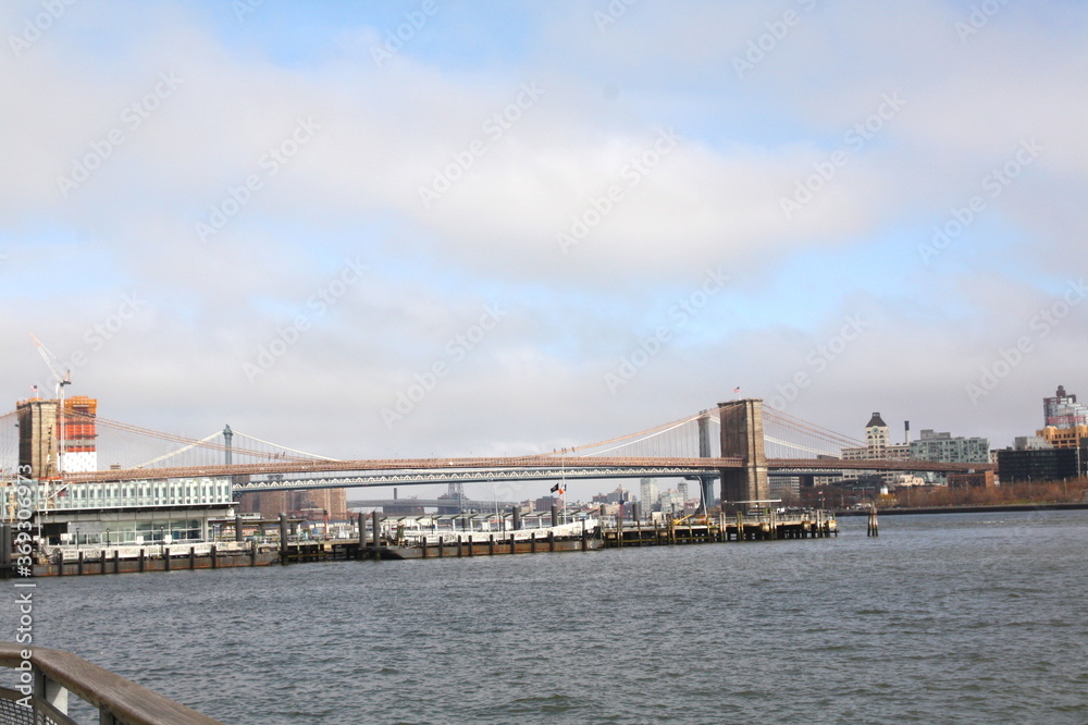 Famous Brooklyn Bridge in New York City, USA with beautiful blue sky and Manhattan skyline and Manhattan Bridge in background, America.