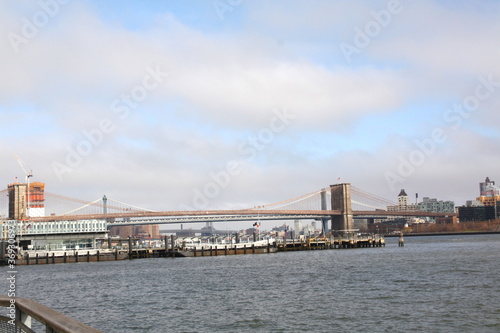 Famous Brooklyn Bridge in New York City, USA with beautiful blue sky and Manhattan skyline and Manhattan Bridge in background, America.