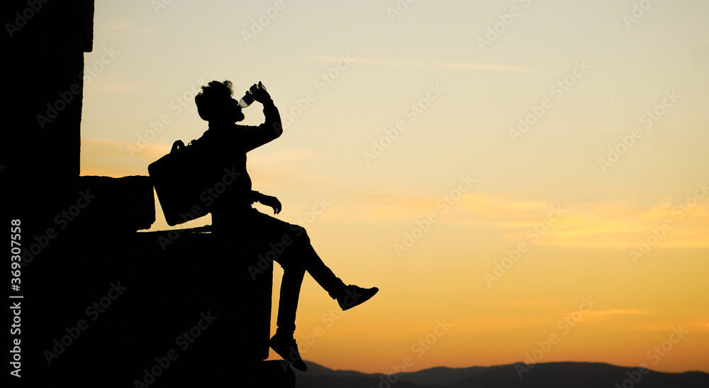 Silhouette of man drinking water