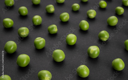 Pattern of green peas on black background