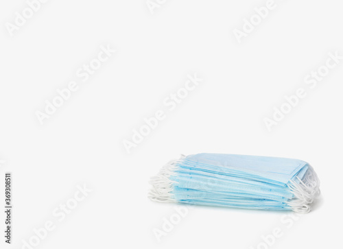 A stack of blue medical masks on a white background. Protection and prevention against coronavirus  covid-19 and other viruses. Healthcare and medical concept.