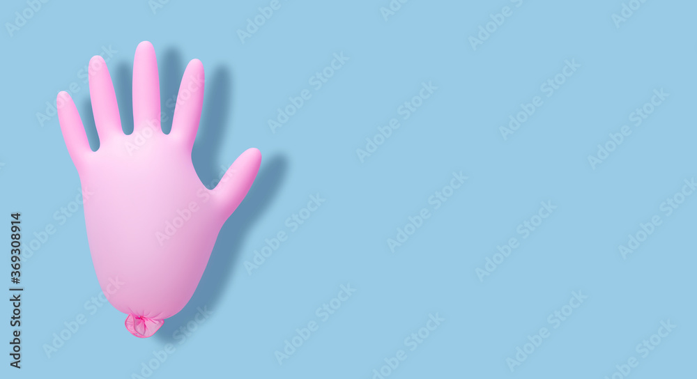 Obraz premium Pink inflated medical glove on a blue background. Banner. Prevention of coronavirus, covid-19. Minimal healthcare concept.