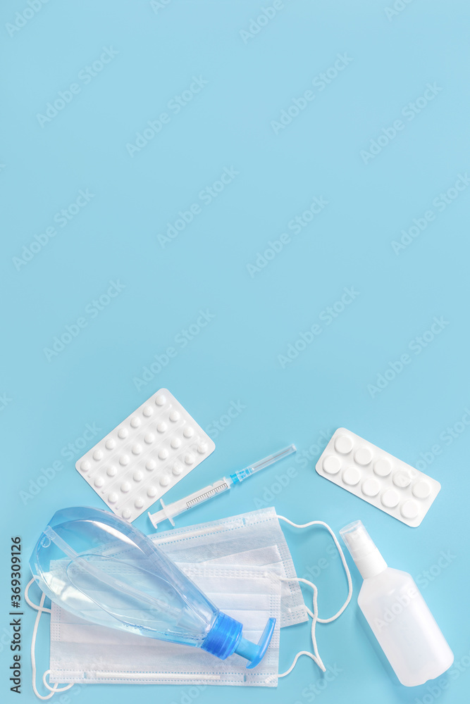 Medical kit. Means for the prevention and treatment of colds or coronavirus. Mask, sanitizer and medication on a blue background. Covid-19, healthcare concept.
