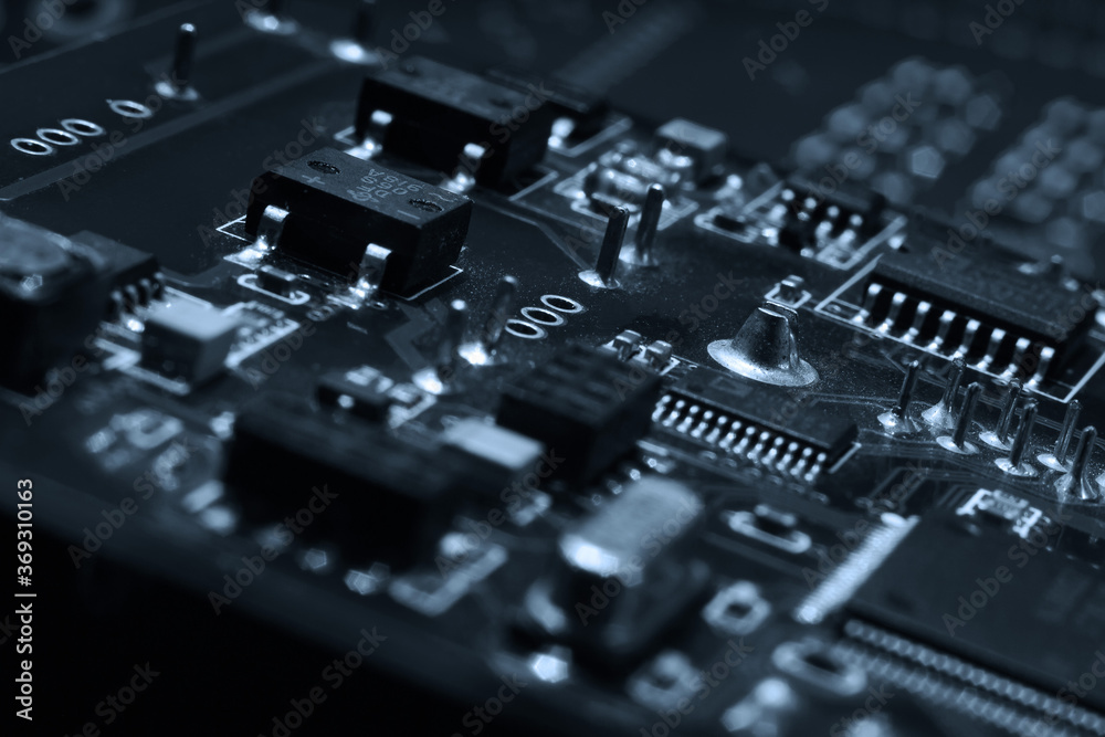 Fragment and components of a motherboard (PCB) of computer technology with many elements. Macro photography of processors and transistors. IT industry background Fragment and components of a motherboard (PCB) of computer technology with many elements. Macro photography of processors and transistors. IT industry background