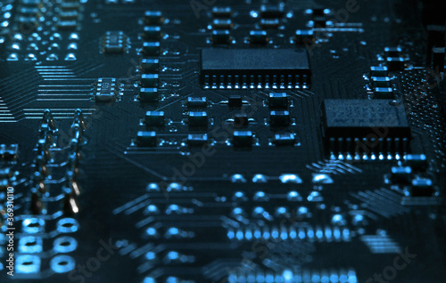 High-tech electronic board (PCB) with processor, microcircuits and luminous digital electronic signals. Close up macro photography photo
