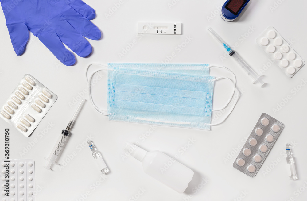 Gloves, syringe, mask, tablets and sanitizer, test on a white background. Means for the prevention and treatment of coronavirus.